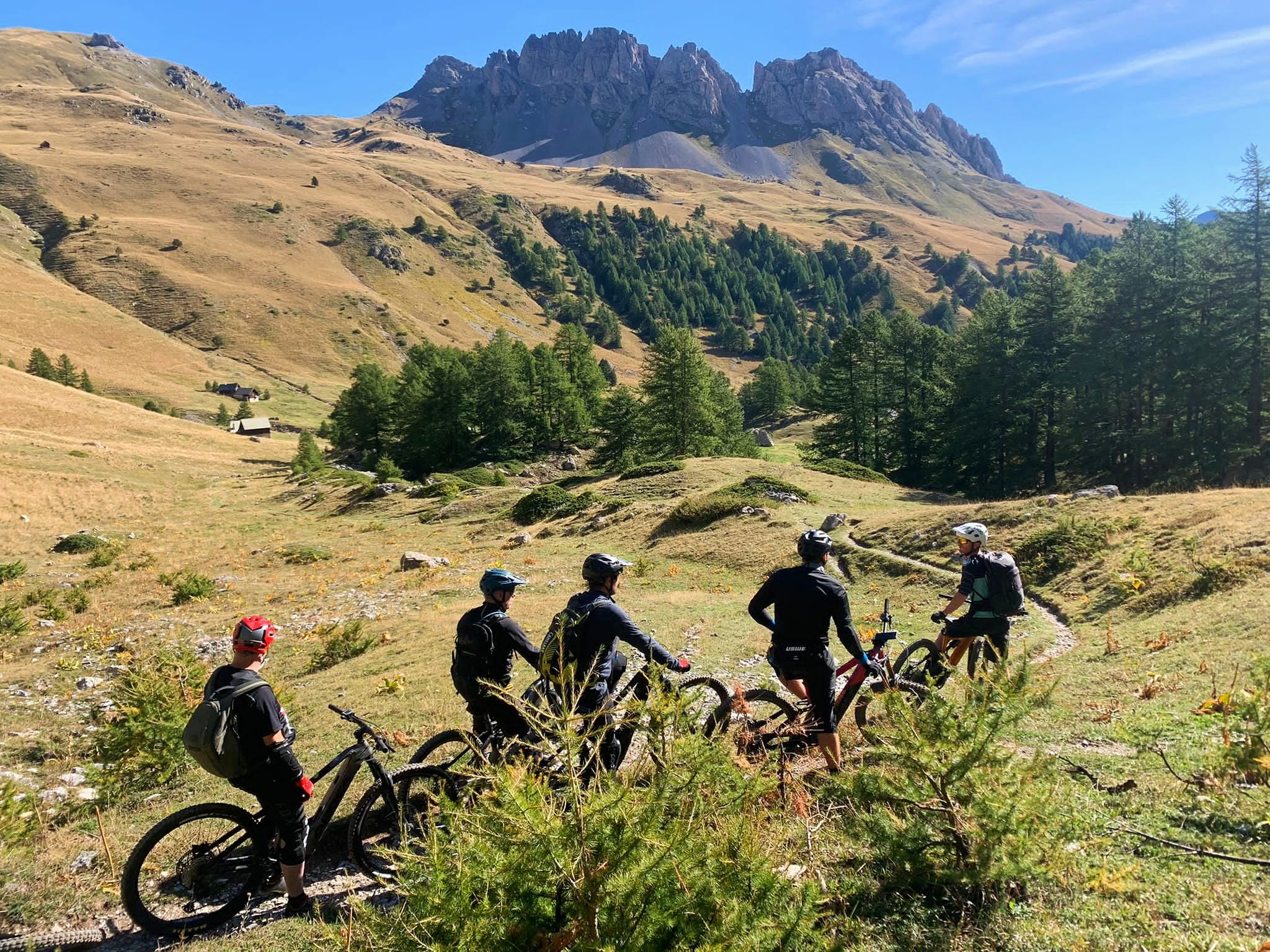 un groupe de 5 cyclistes font du vtt électrique dans la vallée de la clarée accompagnés par un moniteur